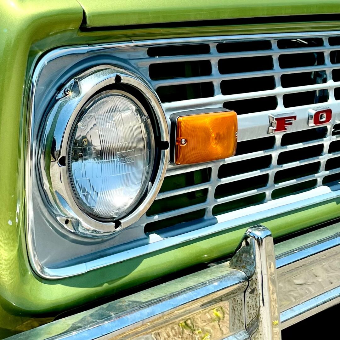 Close-up angled shot of the green grill of a 1970s? ford Bronco.