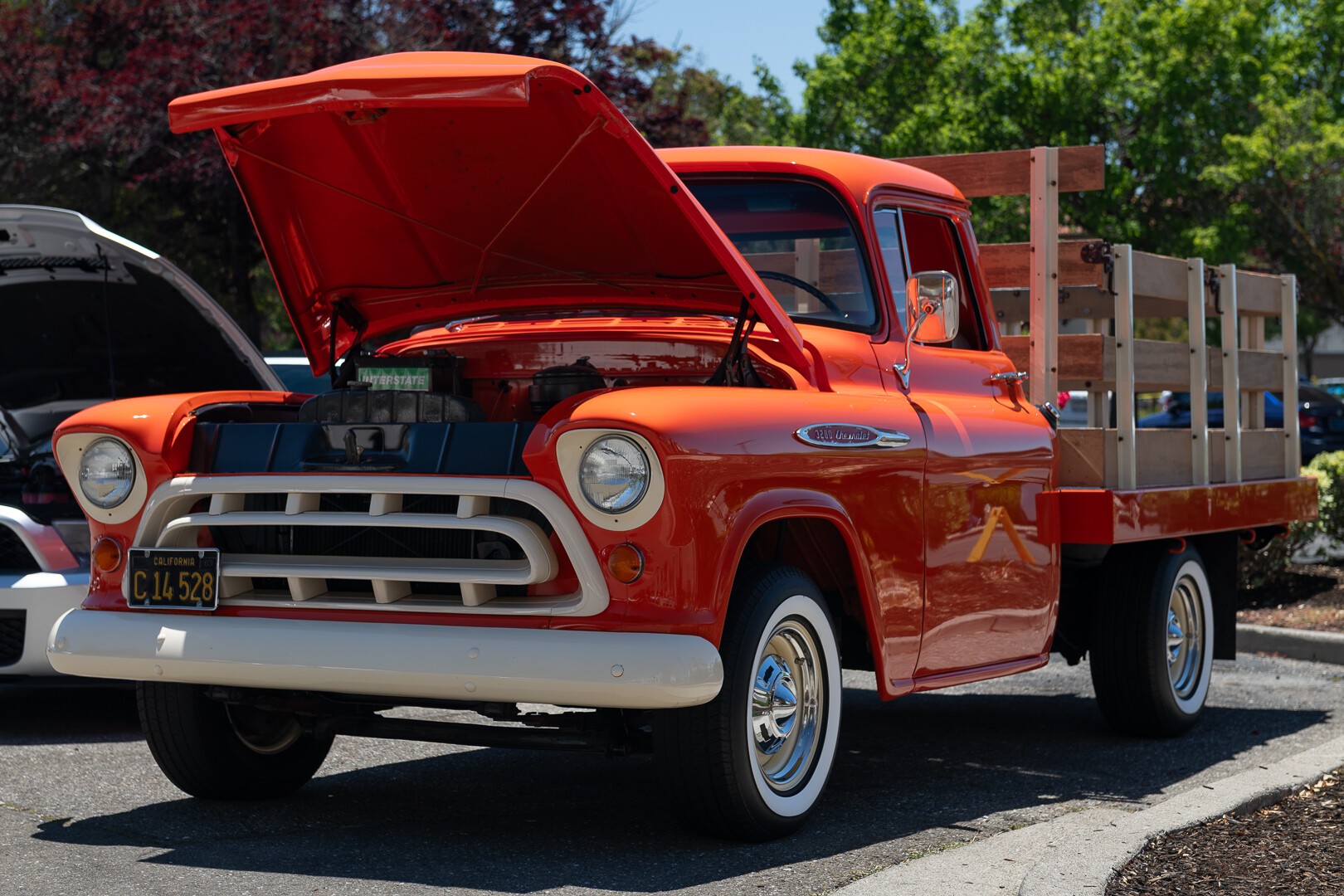 An orange truck with a custom wooden bed. An orange truck with a custom wooden bed.