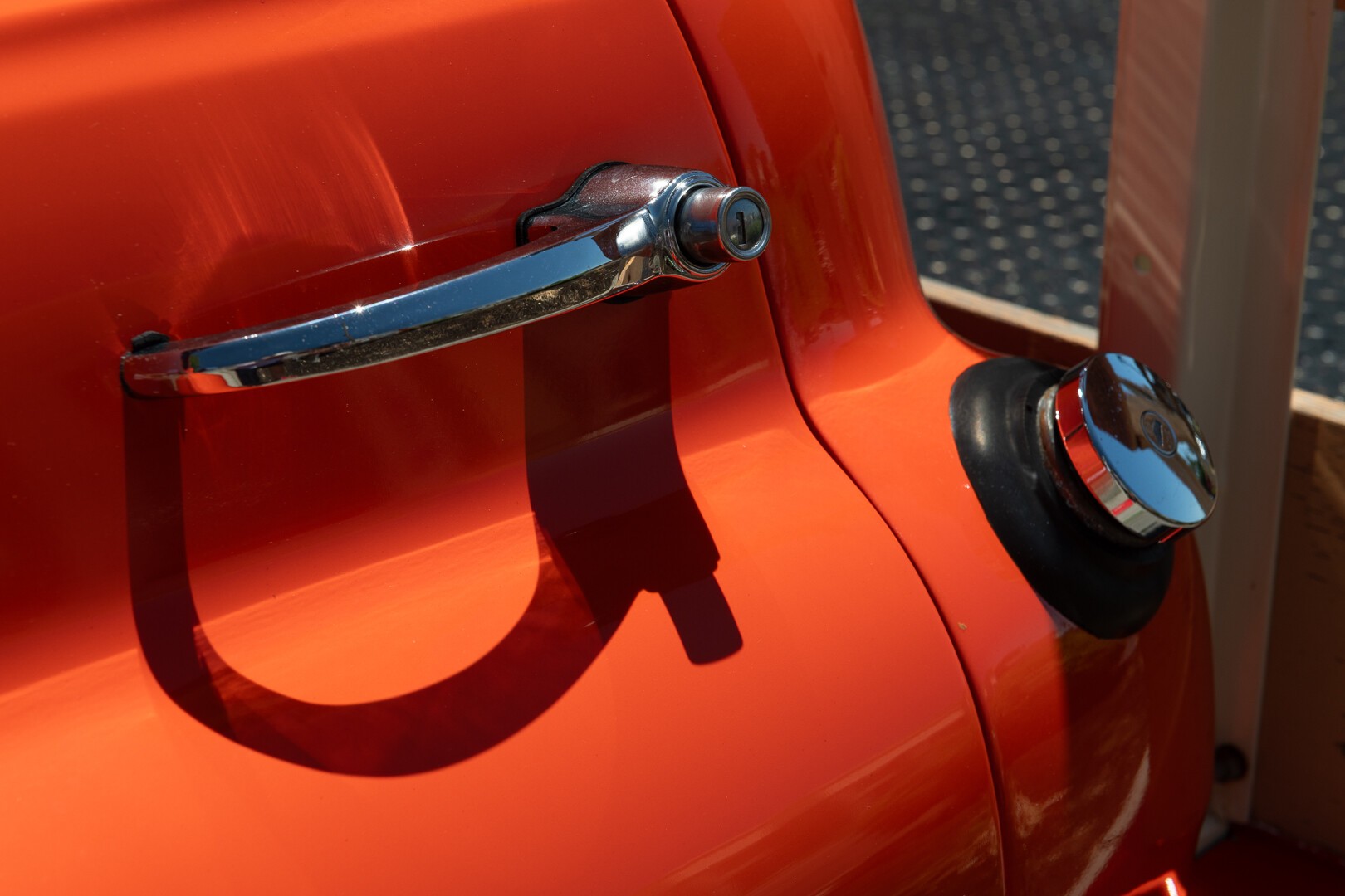Chrome door handle and fuel filler cap against orange bodywork Chrome door handle and fuel filler cap against orange bodywork