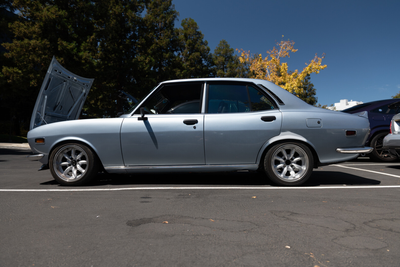 A silver Japanese sedan with an open hood