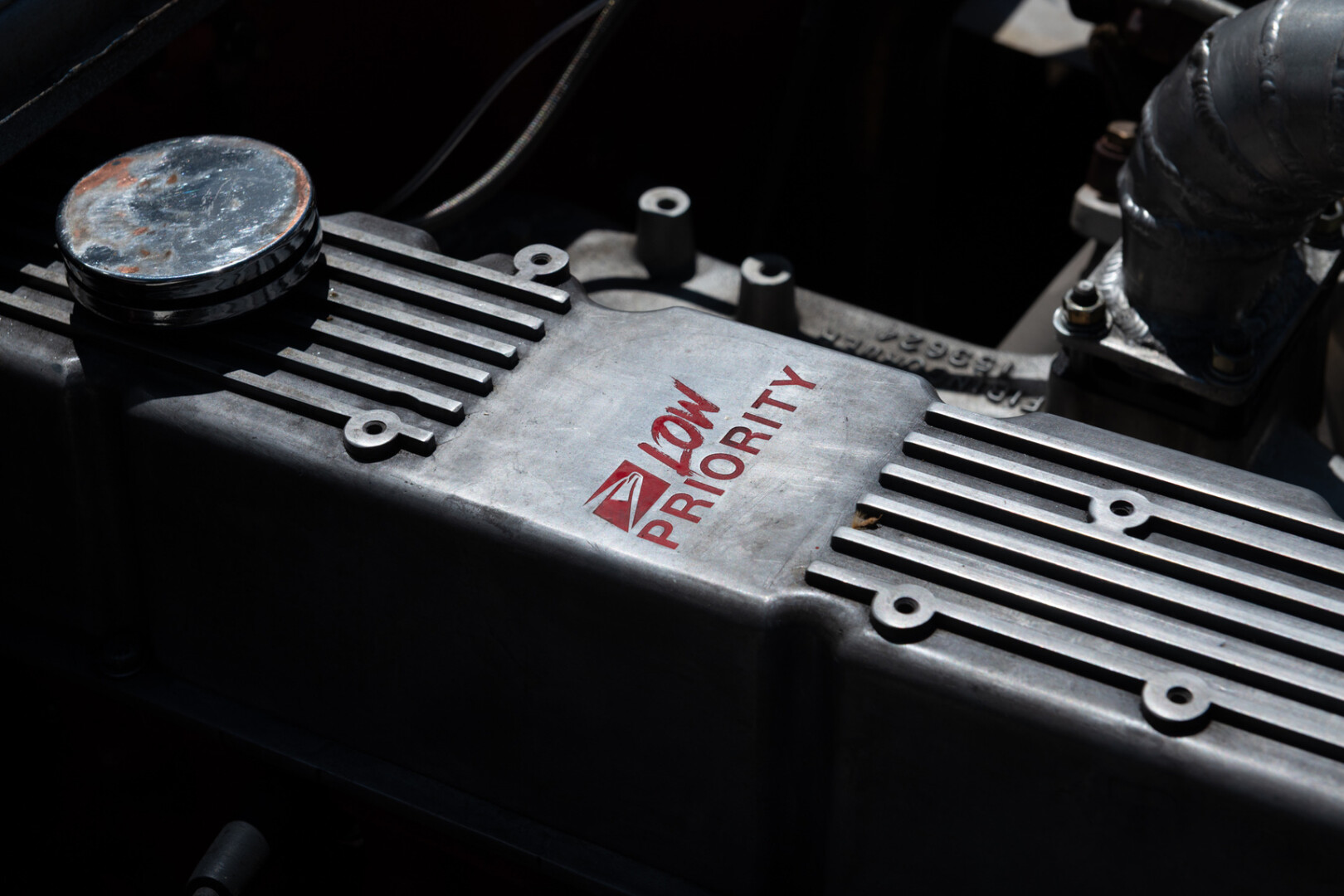 Close-up of the engine block. A fake USPS logo in red is printed on it with the words “LOW PRIORITY”.