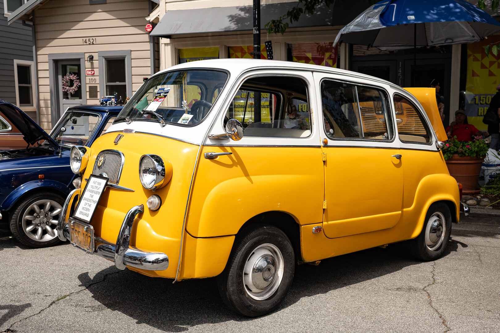A vintage yellow and white minivan, with chrome accents.