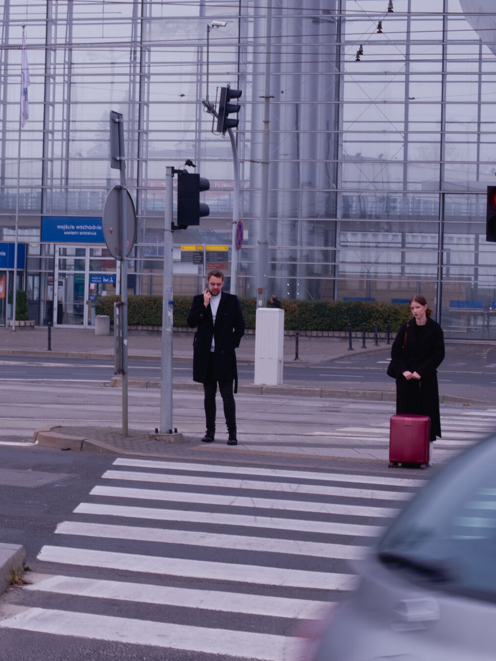 Two people standing at an intersection zebra