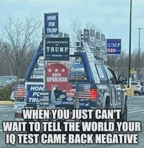 An image of a vehicle decorated in a large number of Trump signs with the caption 