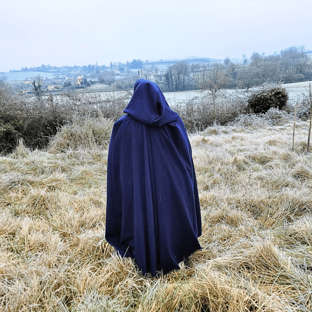 On voit une personne grosse de dos, dans une longue cape bleu nuit, qui regarde au loin un paysage gelé.

You're behind a fat person in a deep blue long cloak, looking away at a frozen landscape