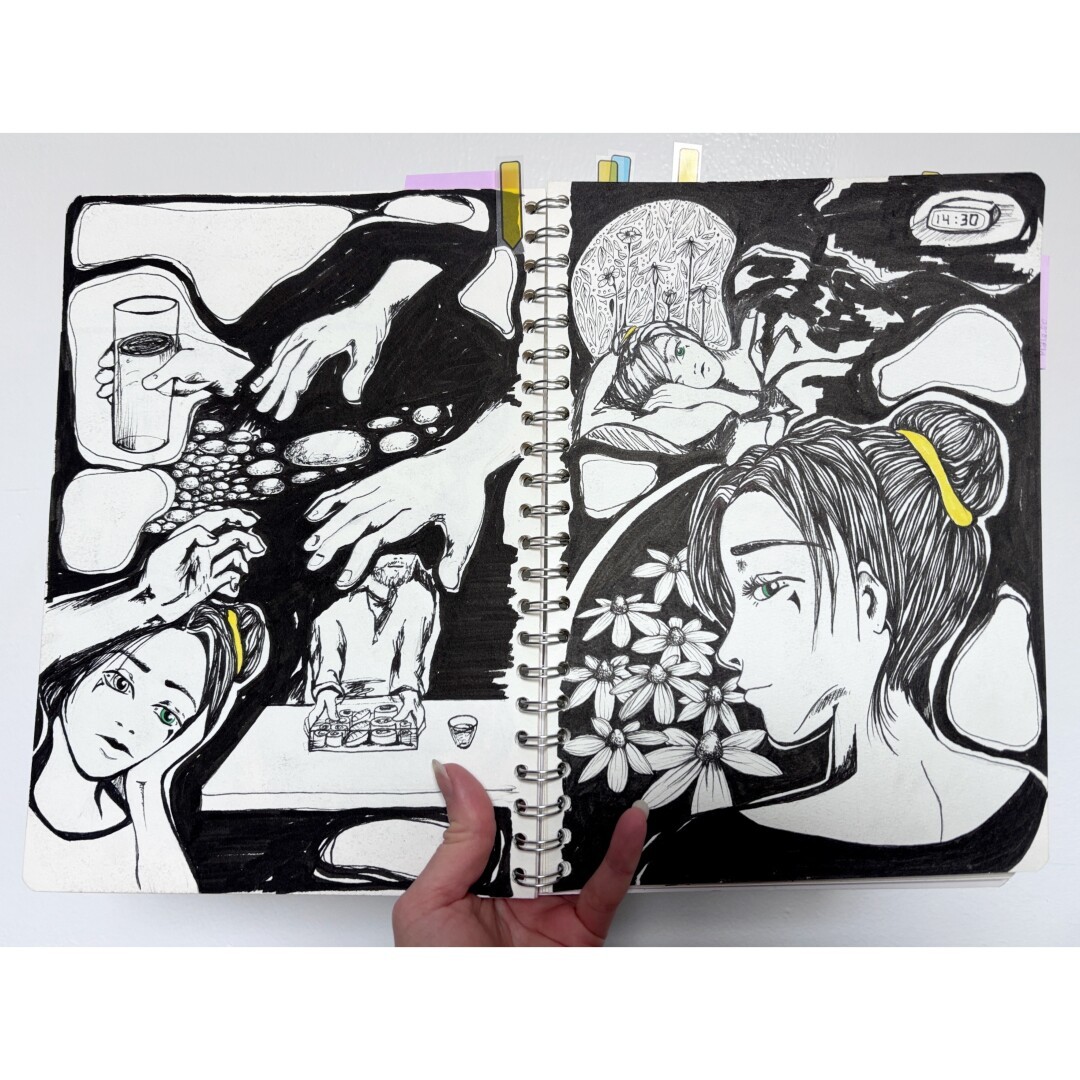 Open sketchbook held in front of a white wall, with black ink drawings of hands, rocks, a person holding their head and another a box of sushi on the left page, and a feminine person on the right page looking behind them towards the viewer. There’s flowers similar to rudbeckia in front of her. On the up of the page the same person laying in a bed with eyes open and flowers surrounding her.