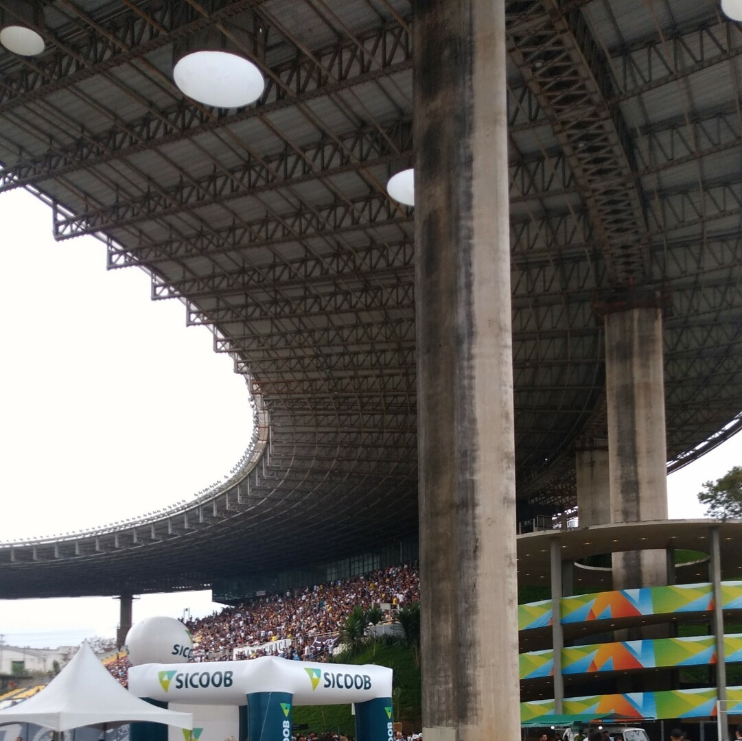 picture at the entrance of a football stadium with a packed stand at the back.