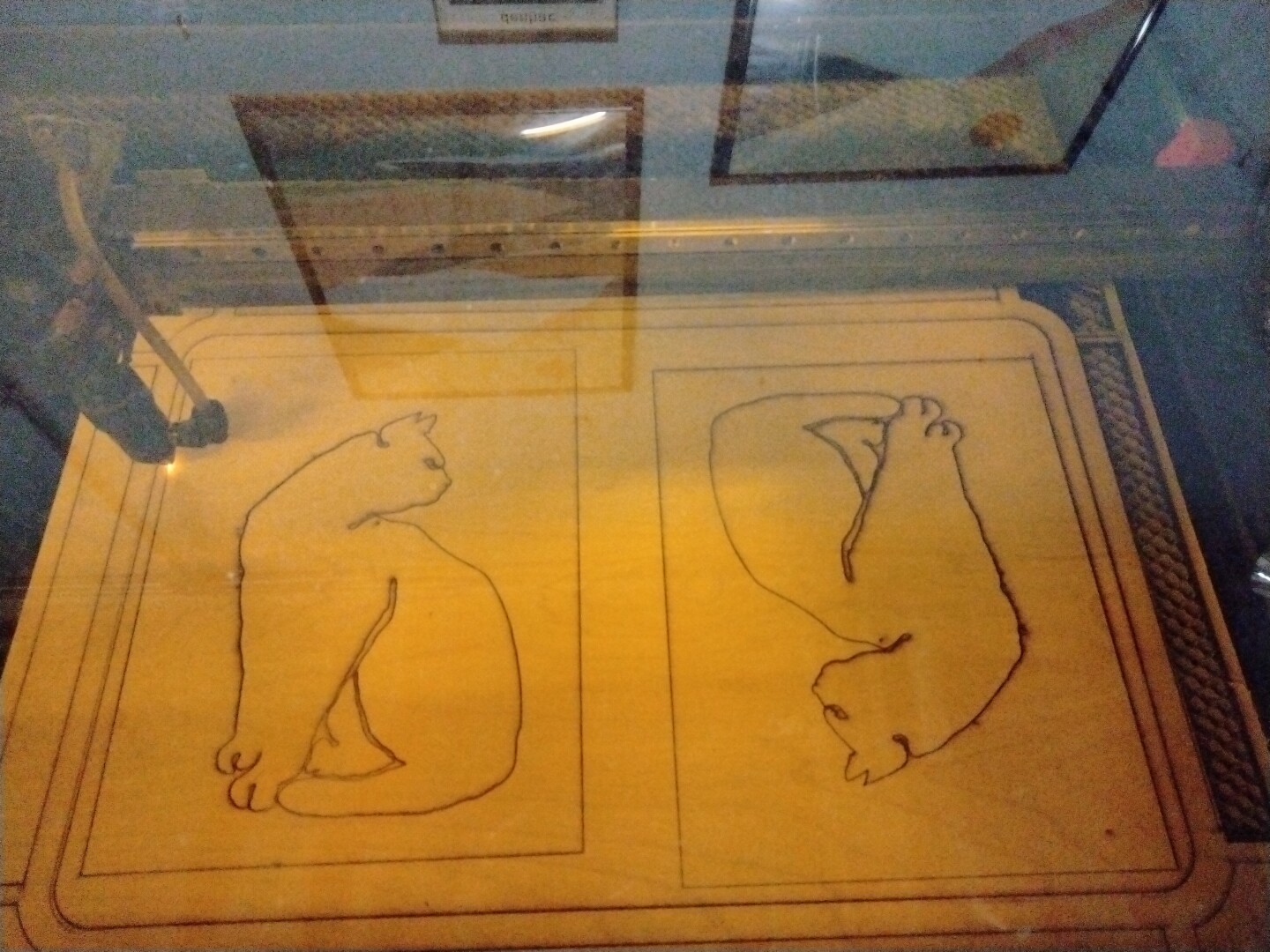 laser cut images of cats almost complete while laser cutter bring cut