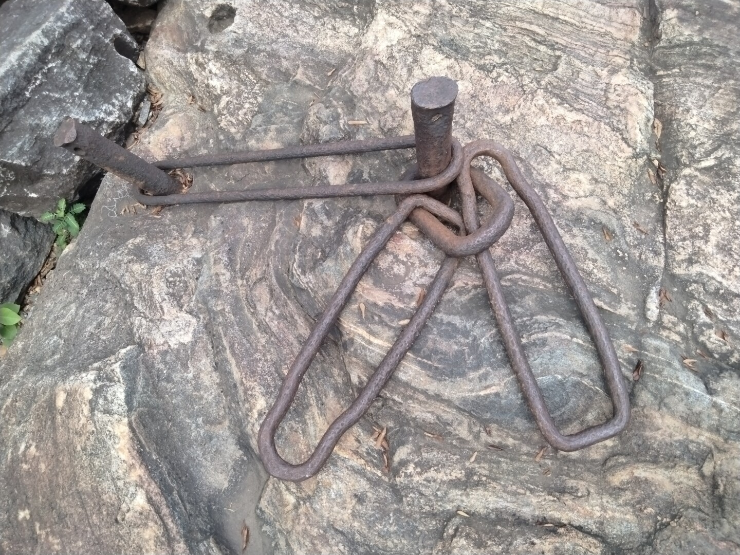 Rusty iron lips and posts imbedded in rock