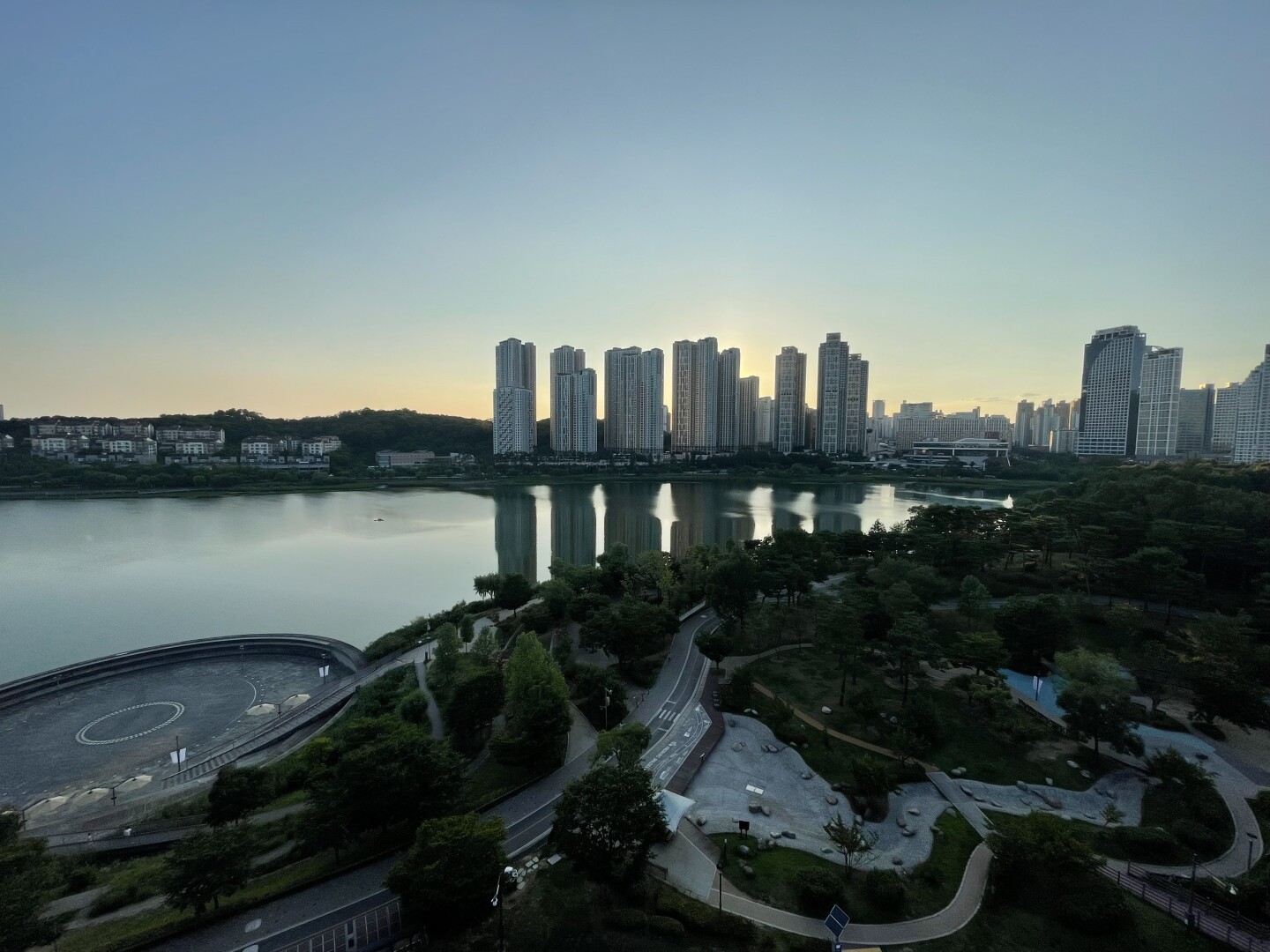 The same view of a group of high rises on the opposite side of the lake with the sun now set but still illuminating the horizon.