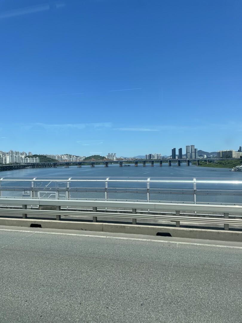 A view of the Han river from the bus with high rises lining the horizon.
