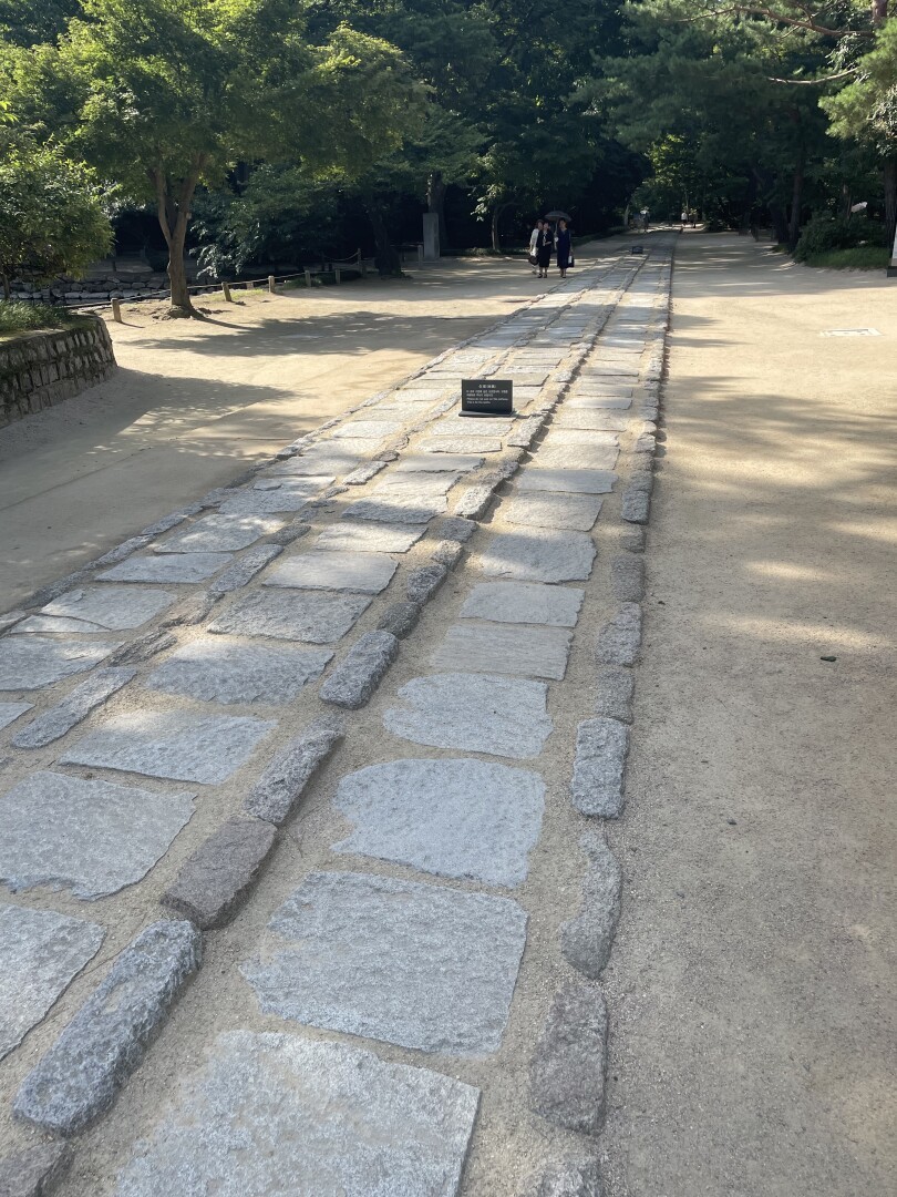 The Ritual Road on the shrine grounds. The middle of the path is paved with three lines of stones separated by smaller stones. The middle central path of stones was reserved for officiants carrying spirit tables during ancestral rituals. The left path was reserved for the crown prince and the path on the right for the king. For everyone else sand paths are present on both sides of the stones.