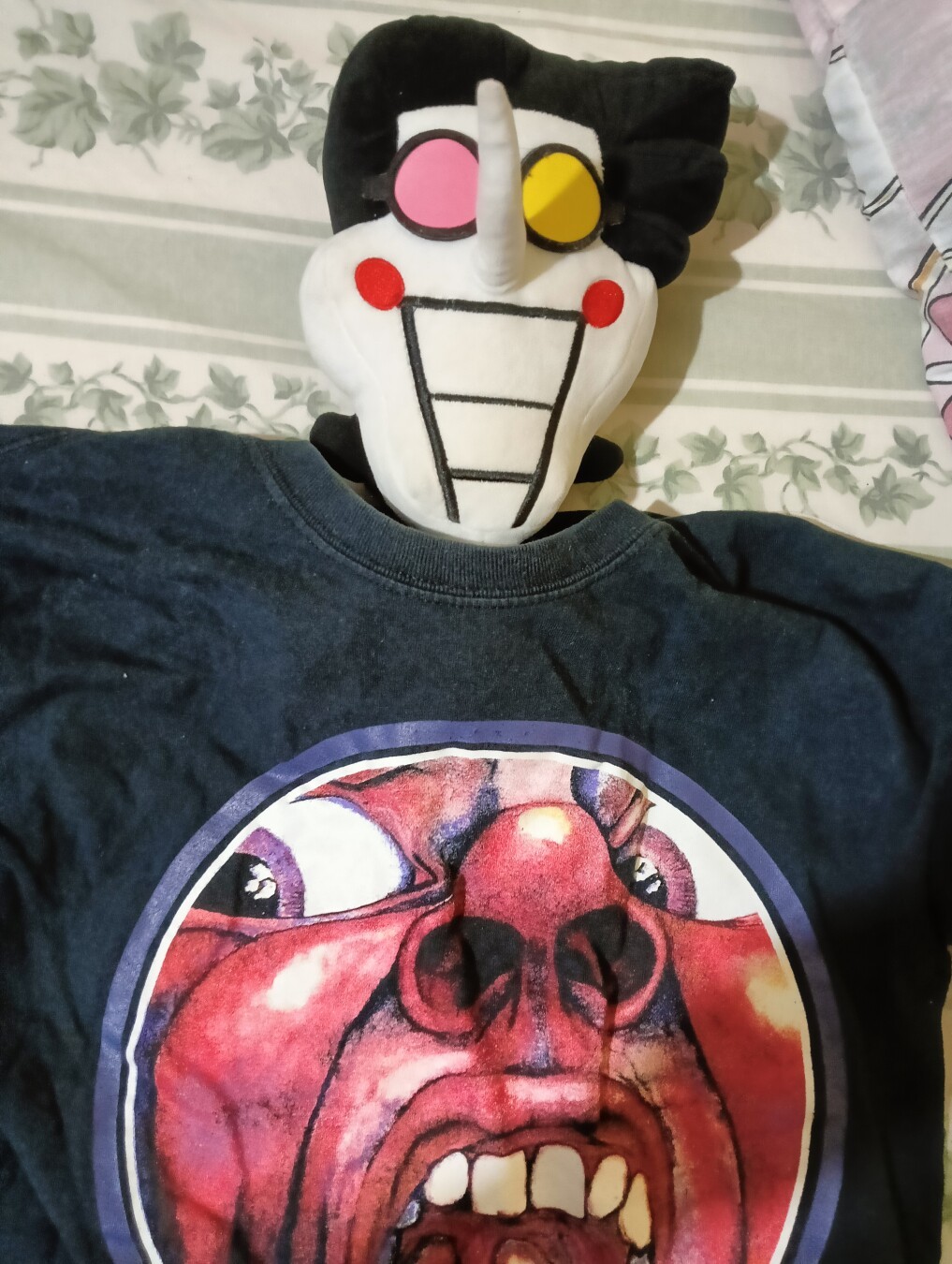 El spamtonluche usando una playera con la icónica imagen del primer álbum de king Crimson. Visto de esta manera pareciera que tiene una cabeza diminuta.