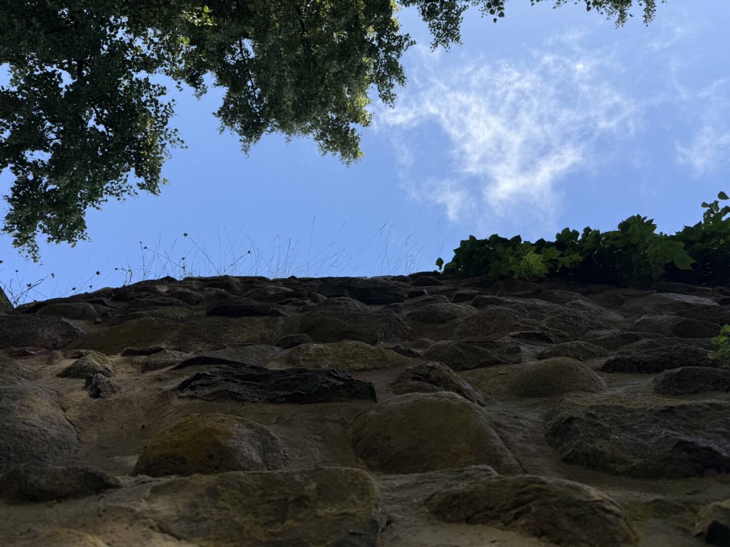 Eine gemauerte Wand von unten Richtung Himmel fotografiert