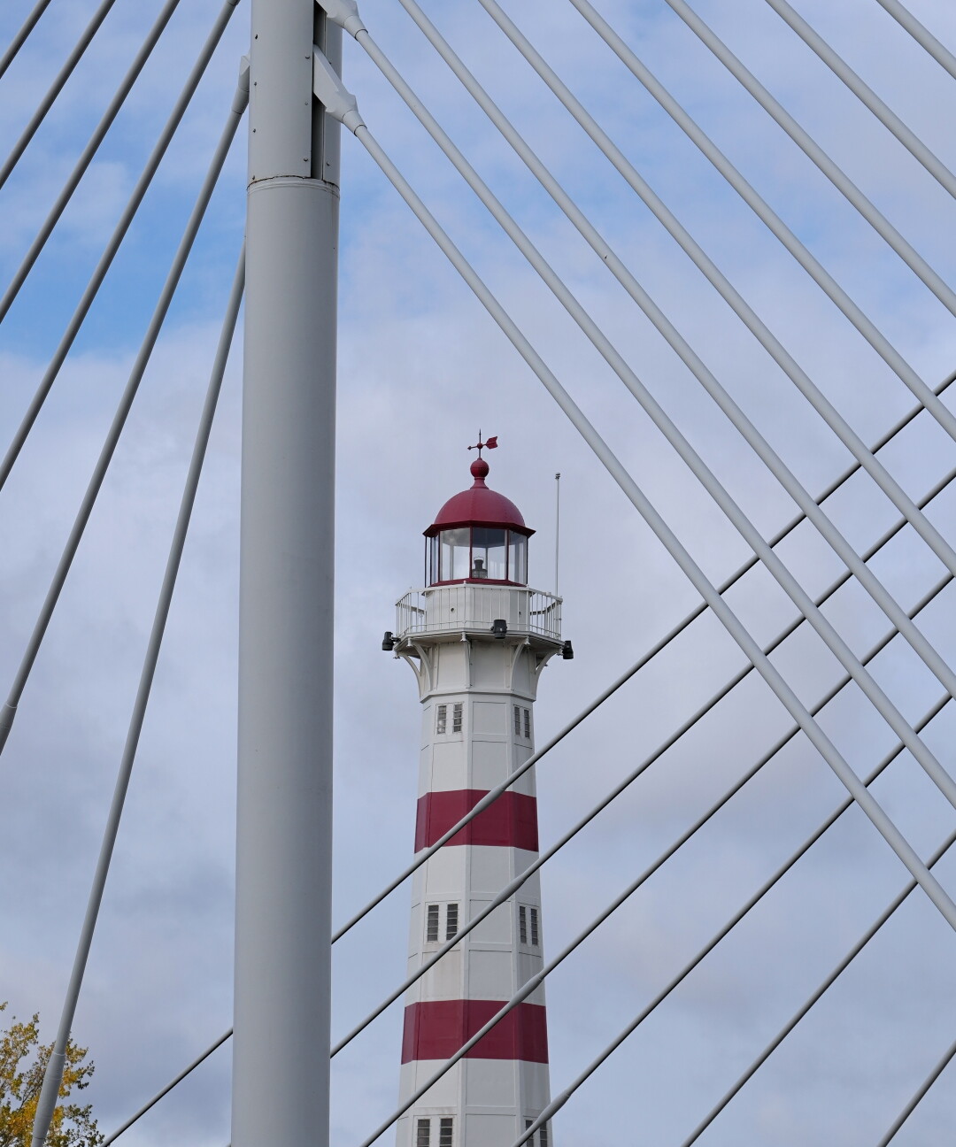 🇬🇧 Picture of the old lighthouse. The University bridge is in between the lighthouse and my location, the pylon and the ropes are creating a nice frame around the top of the lighthouse. The ropes itself are creating a pattern as well, because they are crossing in different angles. 

🇩🇪 Foto des alten Leuchtturms in Malmö. Zwischen meinem Standpunkt und dem Leuchtturm steht die Universitätsbrücke. Die Pylonen und Tragseile der Brücke formen einen Rahmen um die Spitze des Leuchtturms. Die Tragseile treffen durch die Perspektive in unterschiedlichen Winkeln aufeinander, wodurch ein interessantes Muster entsteht.