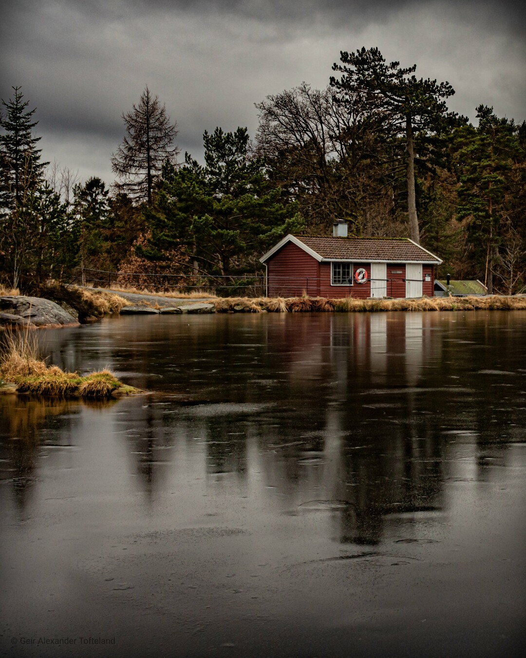 View towards the end of a little lake just ten minutes outside the city center of my hometown Kristiansand. A layer of ice is still covering the whole lake.